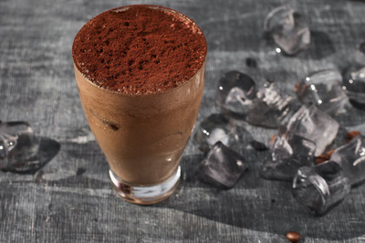 咖啡加牛奶和巧克力。垂直拍摄。浅色背景。冰镇咖啡咖啡和咖啡豆放在桌子上。冷却饮料的概念。夏季饮品